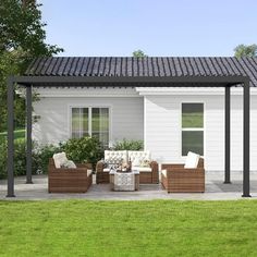 a patio with wicker furniture and an awning on the side of the house