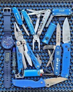 many different types of knives and tools on a blue mat