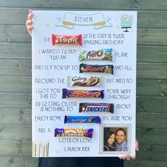 a person holding up a sign with candy on it