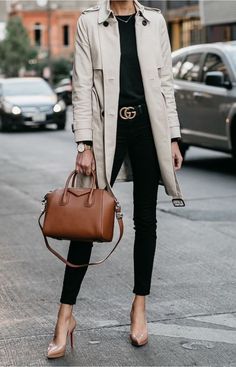 a woman is walking down the street carrying a brown purse and wearing black pants with heels