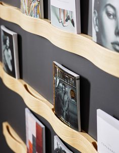 a wooden shelf with pictures hanging on it