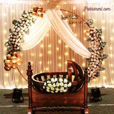 a baby crib decorated with flowers and balloons for a birthday party or wedding ceremony