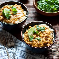 two bowls filled with food on top of a table next to a fork and spoon