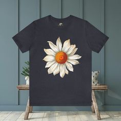 Elevate your style with our Large Daisy Unisex T-Shirt. This classic tee features a prominent large daisy design on the front, offering a clean and stylish look. Available in a wide range of sizes and colors, this versatile tee is the perfect addition to any wardrobe. #16 Boho Classic unisex jersey short sleeve tee fits like a well-loved favorite. Soft cotton and quality print make users fall in love with it over and over again. Ribbed knit collars to bolster shaping. Shoulders are tapered for a better fit over time. Dual side seams hold the garment's shape for longer. Fabric Details Made with 100% Airlume combed and ring-spun cotton, a lightweight fabric (4.2 oz/yd² (142 g/m²)) that is easy to layer, breathable. Perfect for active and leisure wear. Style Features The retail fit is perfect Cotton Short Sleeve T-shirt With Sunflower Print, Casual Cotton T-shirt With Sunflower Print, Relaxed Fit Sunflower Print Graphic Tee, Relaxed Fit Sunflower Print T-shirt With Crew Neck, Graphic Tee With Sunflower Print And Crew Neck, Summer Crew Neck T-shirt With Daisy Print, Summer Daisy Print Crew Neck T-shirt, Cotton T-shirt With Sunflower Print, Short Sleeve, Relaxed Fit Short Sleeve T-shirt With Daisy Print