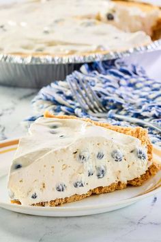 a slice of blueberry cheesecake on a plate next to a pie pan with the rest of the pie in it