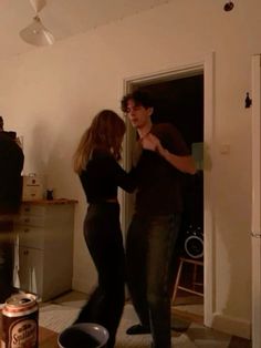 a man and woman dancing in the living room