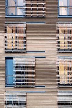 an apartment building with many windows and blinds