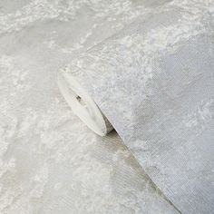 a roll of toilet paper sitting on top of a white tablecloth covered in floral designs