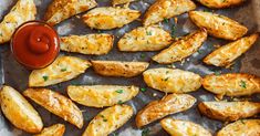 baked potato wedges with ketchup and parsley on a baking sheet, ready to be eaten