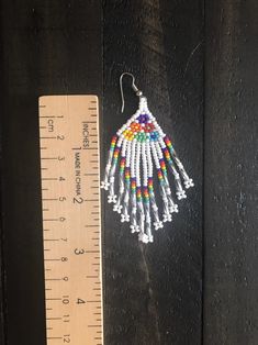 Artisan White Earrings With Beaded Fringe, Traditional White Beaded Fringe Jewelry, White Beaded Fringe Earrings For Festival, White Beaded Fringe Festival Jewelry, Festival White Beaded Fringe Jewelry, Traditional Beaded Dangle Earrings With Tassels, Traditional Beaded Fringe Tassel Earrings For Festivals, Traditional Beaded Tassel Dangle Earrings, White Beaded Earrings For Festivals And Gifts