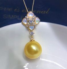 Elegant South Sea Golden Pearl Pendant, 11.9mm, Bright Rich Gold Color with green overtone, Very High Luster.  With beautiful Mother of Pearl and sparkling cubic zircons, Cute and Elegant, Very Well Made.  Cute and Elegant   Lustrous Beauty  Pearl ★ Pearl: Genuine South Sea Golden Saltwater Pearls  ★ Origin: Philippines ★ Size: 11.9mm ★ Shape: Near Perfect Round ★ Color: Natural untreated, Bright Rich Gold Color with green overtone, Beautiful ★ Luster: Very High luster, Wonderful ★ Surface: Nice Yellow Round Pearl Pendant Jewelry, High Luster Diamond Jewelry, Yellow Round Moissanite Jewelry, Golden Pearl, Saltwater Pearls, South Seas, Pearl Pendant, Pendant Necklaces, Mother Of Pearl