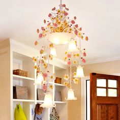 a chandelier hanging from the ceiling in a room with white shelves and doors