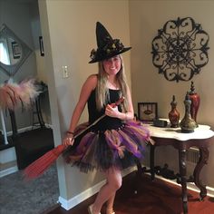 a woman in a witch costume holding a broom