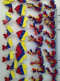 some red, yellow and blue cupcake toppers are on a white table next to a keyboard