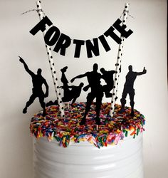 a birthday cake decorated with silhouettes of people dancing and confetti on top