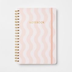 a notebook with the word notebook written in gold foil on top of it, sitting on a white surface