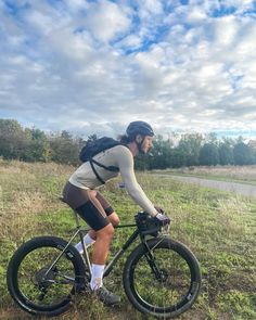 a man riding a bike on top of a lush green field