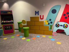 an indoor play area with toys and games on the floor in front of it,