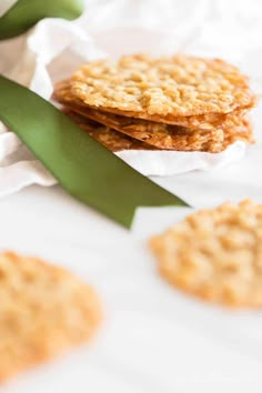 some cookies are sitting on top of each other with a green ribbon around them and tied to white paper