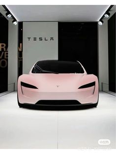 a pink car is on display in a showroom