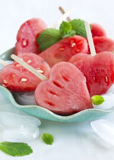 watermelon skewers in a bowl with mint leaves