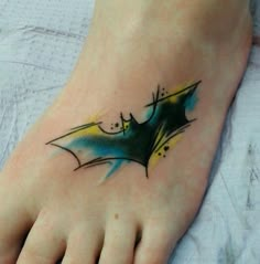 a foot with a bat tattoo on it