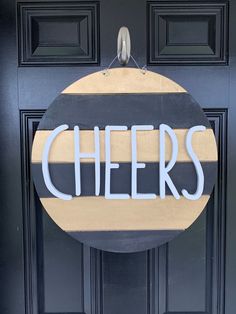 a door sign that says cheers hanging on the side of a black door with yellow and white stripes