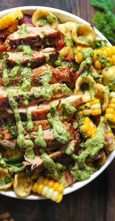 a bowl filled with meat, pasta and guacamole sauce on top of it