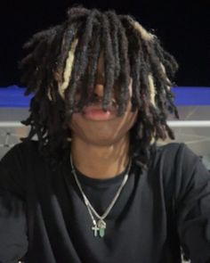 a man with dreadlocks sitting in front of a laptop computer