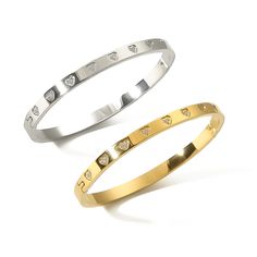 This beautiful gold or silver bangle with Hearts motifs is crafted from stainless steel plated with 18k Gold with White Diamonds Cubic Zirconia that will remain durable and unaffected by daily wear. Showcase your unique style with this intricate piece and be sure to turn heads as you walk by. One size 48mm X 60mm Our elegant Bracelets are a lovely gift for women of all ages. Valentine's Day, Birthdays, Christmas, Weddings, Graduations, or any occasion… It is wrapped in a beautiful gift box with Christmas Weddings, Gold Armband, Elegant Bracelet, Gold Bangle, Silver Bangle, Silver Pieces, Silver Bangles, White Diamonds, Gold Bangles