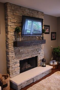 a living room with a television mounted on the wall above a fire place and rugs