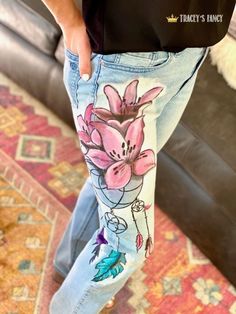 a person wearing jeans with flowers painted on them