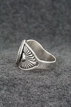 This finely crafted sterling silver ring was made by Navajo silversmith Derrick Gordon. The back is signed Derrick and stamped sterling.Size: 9.5Length: 5/8"Free shipping on all orders! We ship with USPS and always include tracking. All orders ship within a day of payment.Returns are accepted up to 30 days after you receive your order. Just send us a message. Our shop offers cash back or store credit. The item must be returned in new condition. Sterling Silver Turquoise Ring With Concho, Silver Turquoise Concho Ring In Sterling Silver, Silver Southwestern Style Rings, Southwestern Style Untreated Silver Rings, Silver Concho Rings Perfect For Gifts, Silver Concho Rings For Gift, Handmade Silver Western Style Rings, Handmade Western Silver Rings, Western Style Untreated Sterling Silver Rings