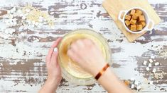 someone is mixing something in a bowl on the table with other ingredients and utensils