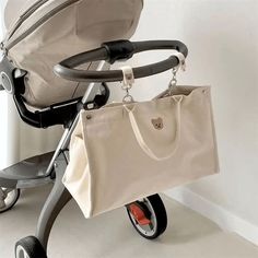 a baby stroller with a handbag attached to it's handlebars