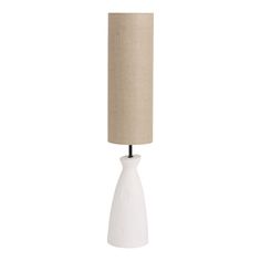 a white table lamp with a beige shade on it's base and a black cord