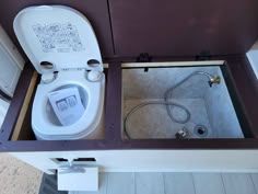 an open toilet sitting inside of a wooden box