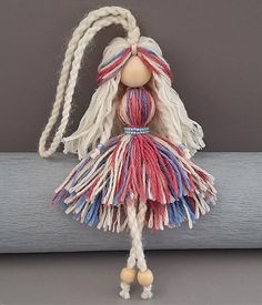 a doll with long white hair and braids on it's head is hanging from a rope