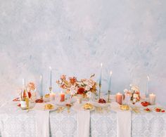 a table topped with lots of food and candles