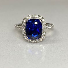 a blue and white diamond ring sitting on top of a table