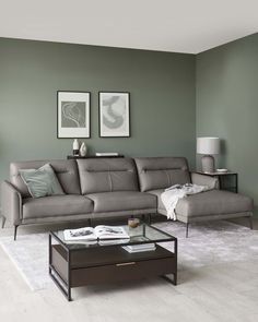 a living room filled with furniture and a coffee table in front of a gray wall