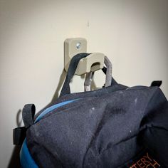 a back pack hanging on the wall next to a light switch