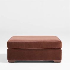 a brown footstool sitting on top of a white floor