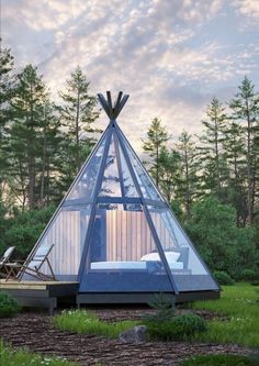 a glass cabin in the middle of a forest