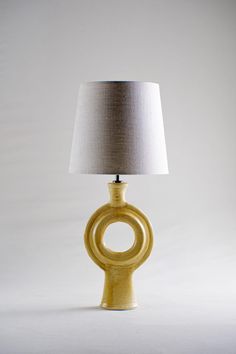 a table lamp with a white shade on it's base and a circular design