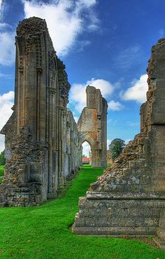 the ruins of an old church with green grass