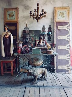 a room with an old fashioned table and sheep figurines