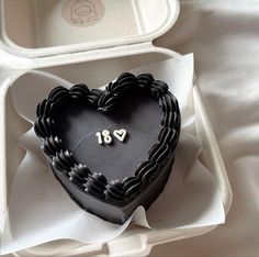 a black heart shaped cake in a box