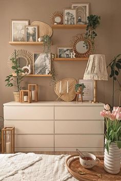 an image of a living room with pictures on the wall and flowers in vases