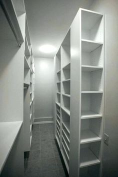 an empty walk in closet with white shelves